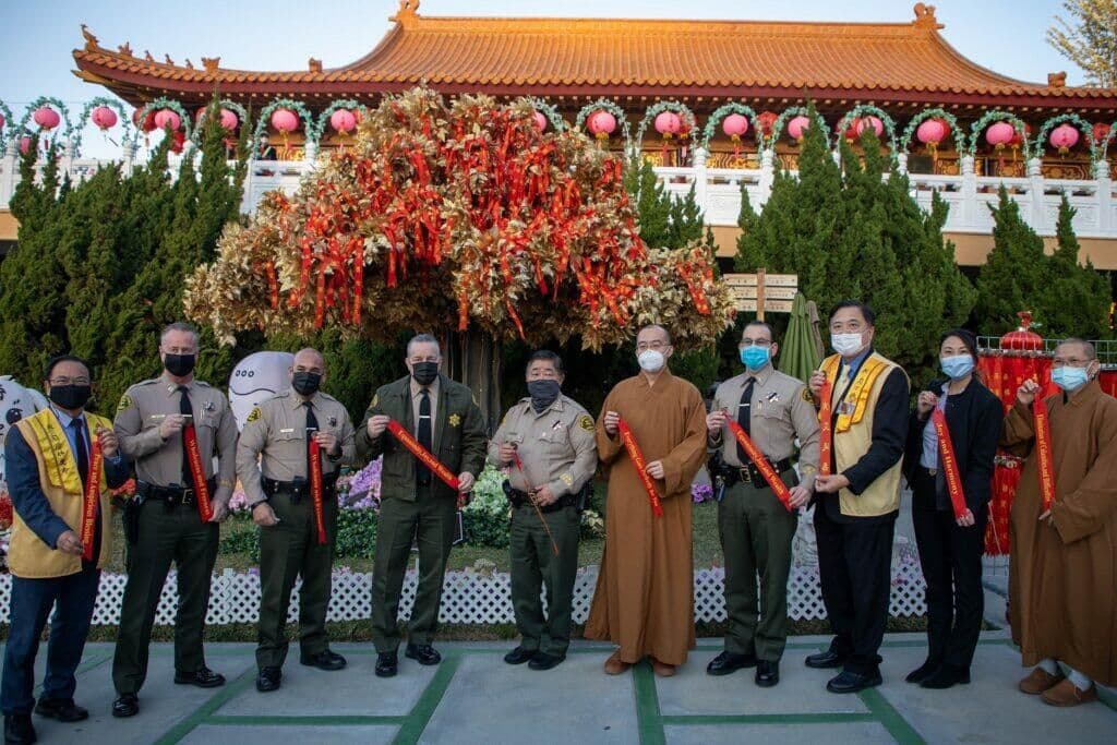 洛縣警察局代表團、社區領袖與法師在西來寺手持祈願帶合影