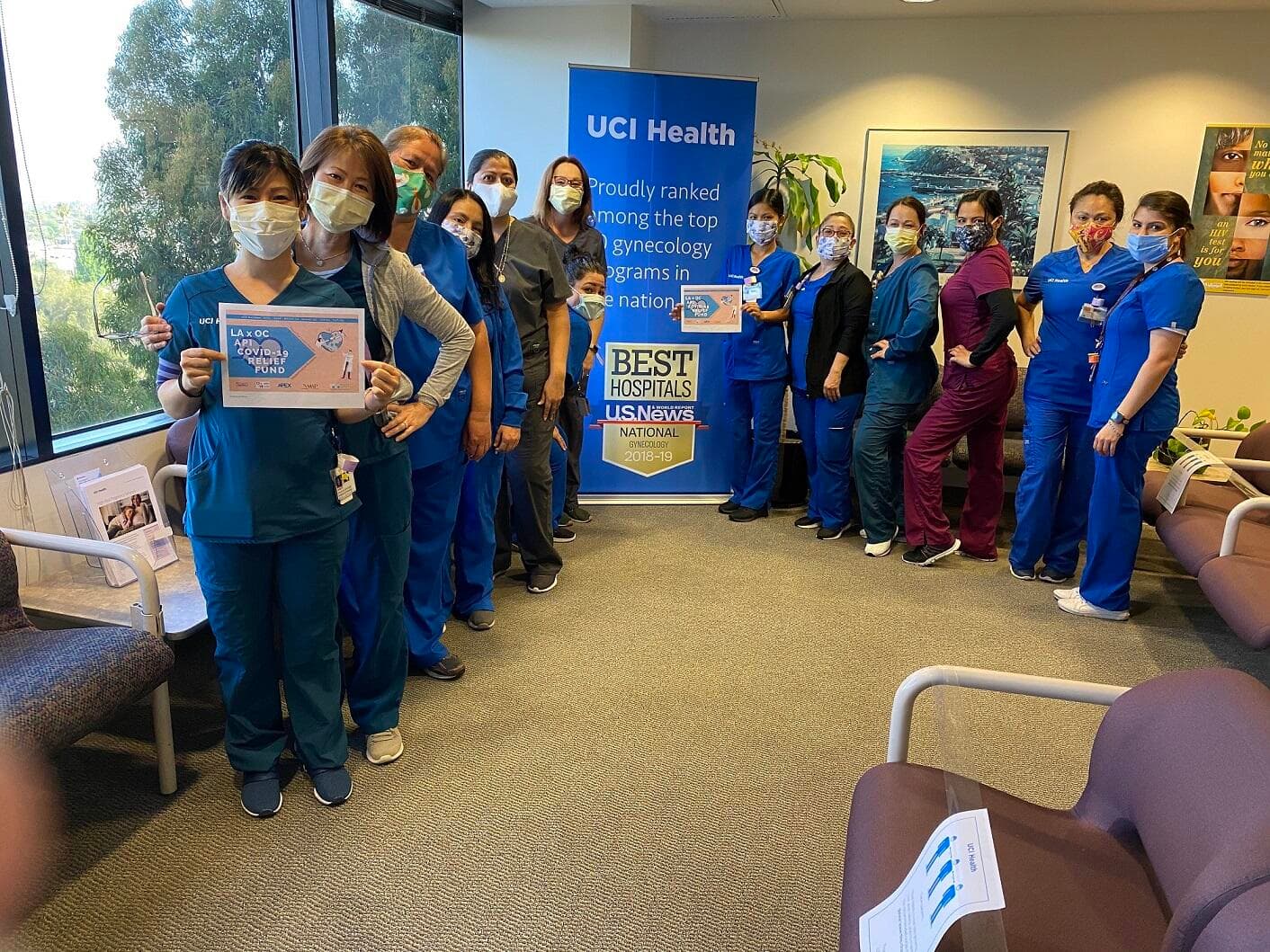 UCI Health staff holding thank-you signs after receiving meals from Spicy Noodle House