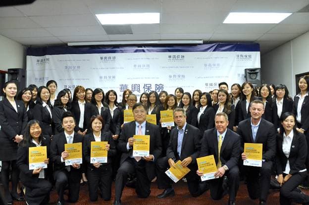 華興保險團隊與加州全保代表在哈仙達崗宣導巴士停留點手持宣傳冊合影