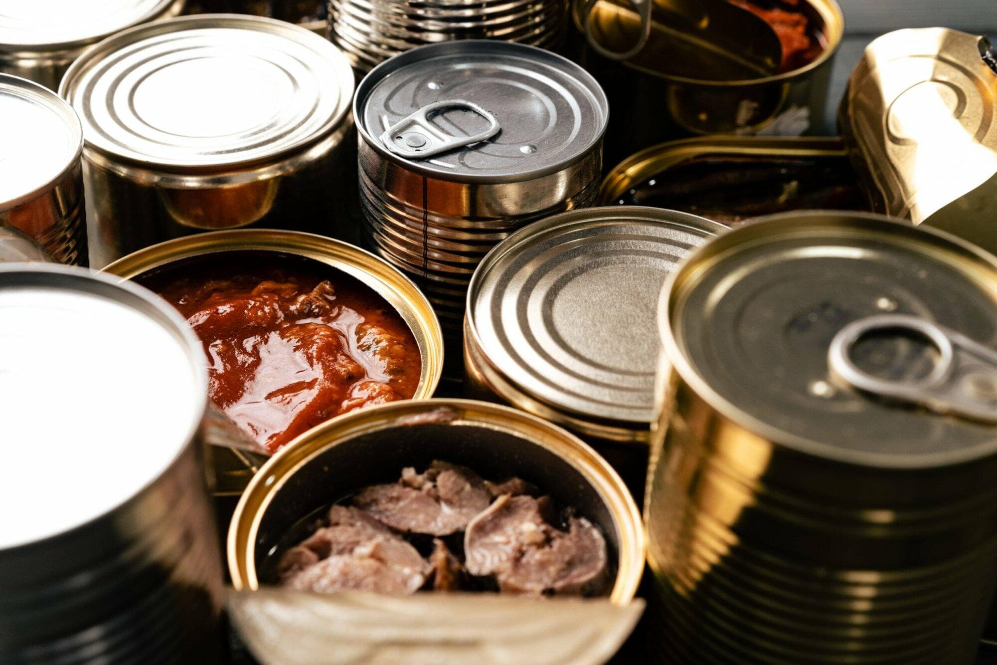 木桌上排列多个鱼罐头，示意食品罐头用马口铁关税