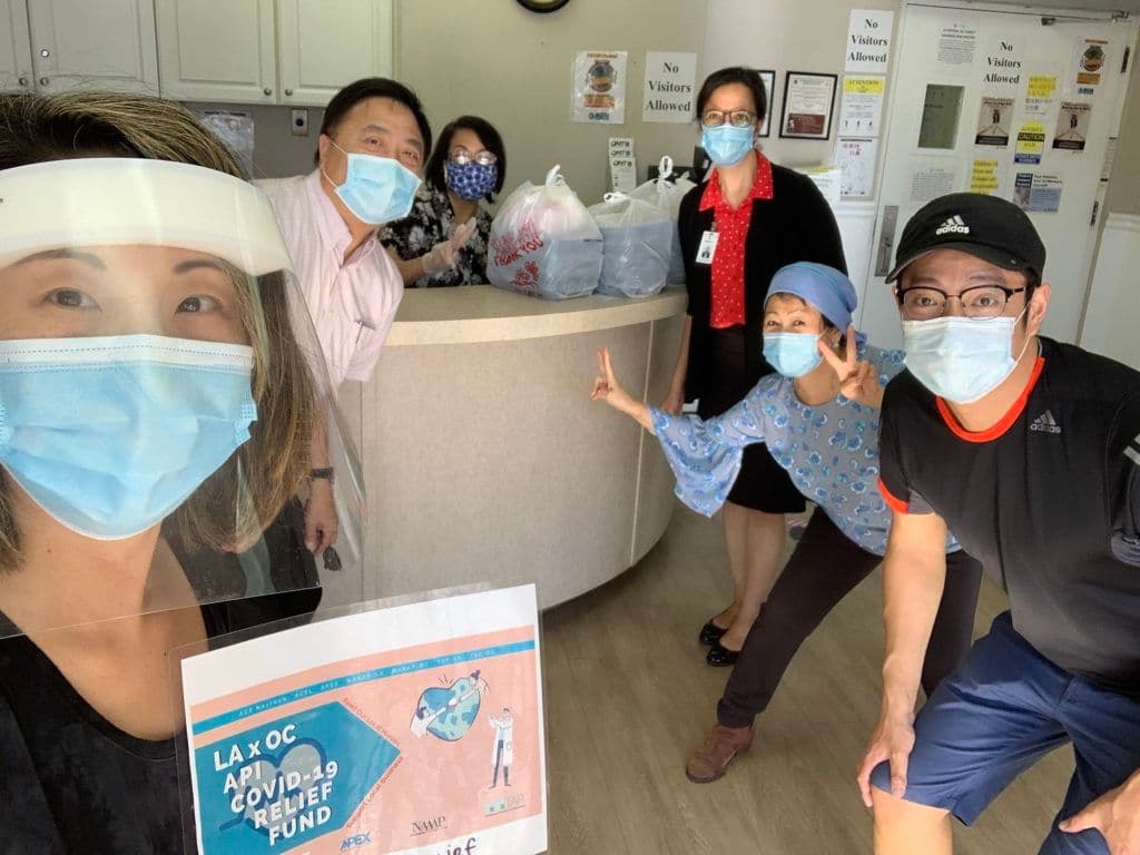 志工與Sunny Village Care Center員工手持紓困金計劃標牌合影