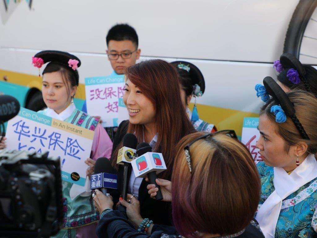 華興保險代表在哈崗總部接受媒體採訪，身旁為身穿清宮服飾的員工