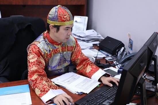 身著清宮古裝的華興保險員工在電腦前工作