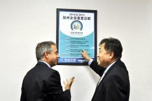 加州全保執行長Peter Lee與華興保險總裁張國興一同查看加州全保重要日期海報